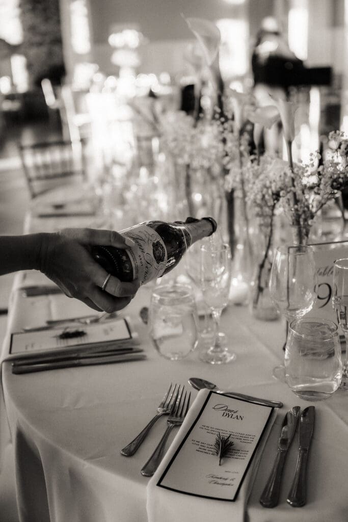 Black and white photo of champagne being poured during a Rylan Inn wedding reception.