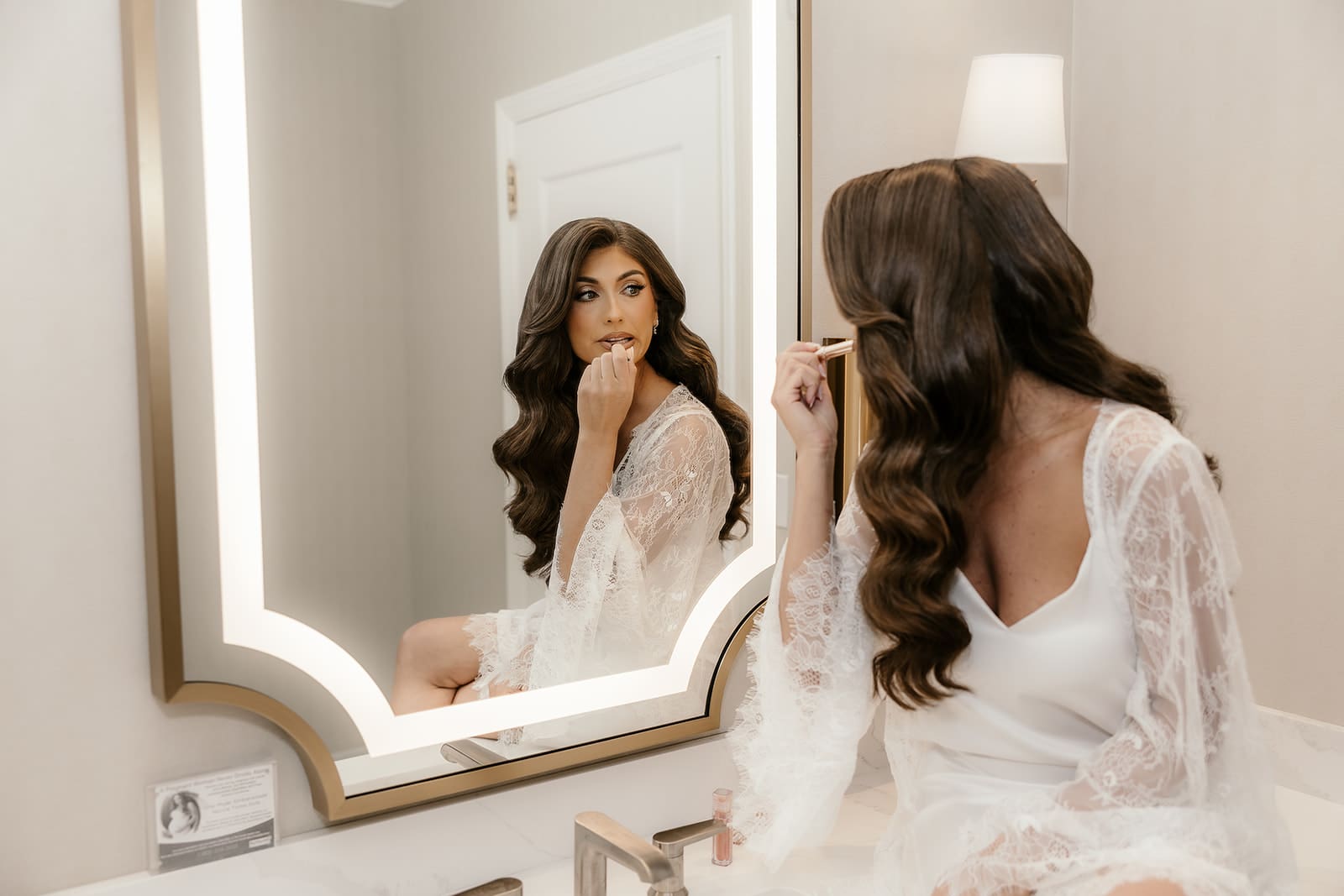 Bride applying lipstick in the mirror at The Palace at Somerset Park.