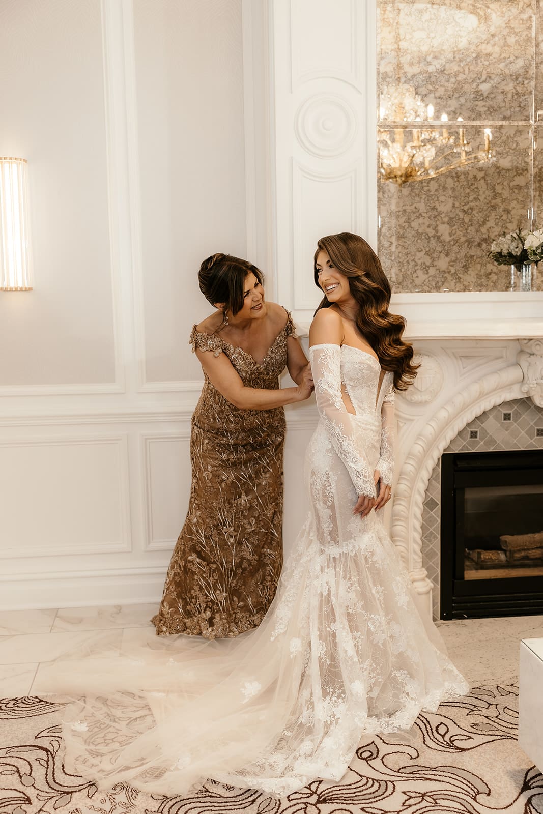 Brides mother helping her get into her dress inside The Palace at Somerset Park.