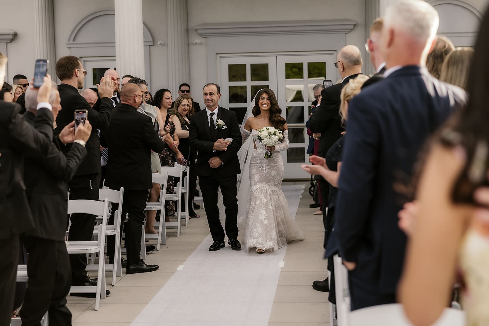 Bride being walked down the aisle by her father.