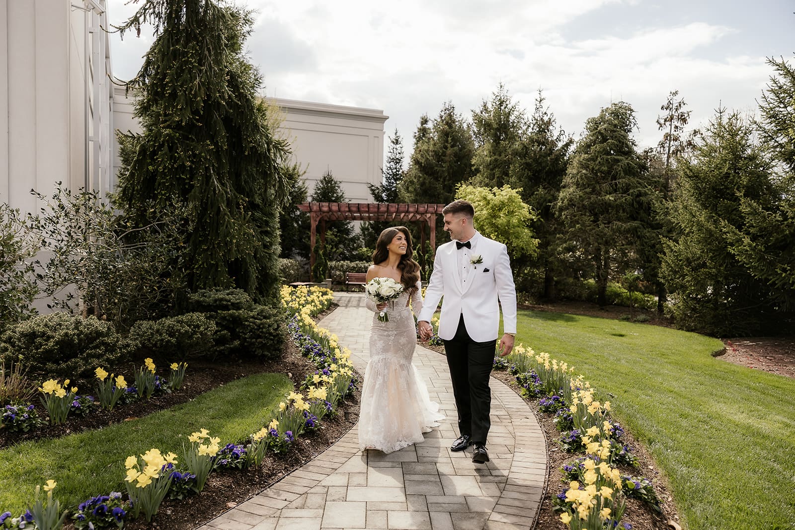Bride and groom walking down a pathway outside of The Palace at Somerset Park.