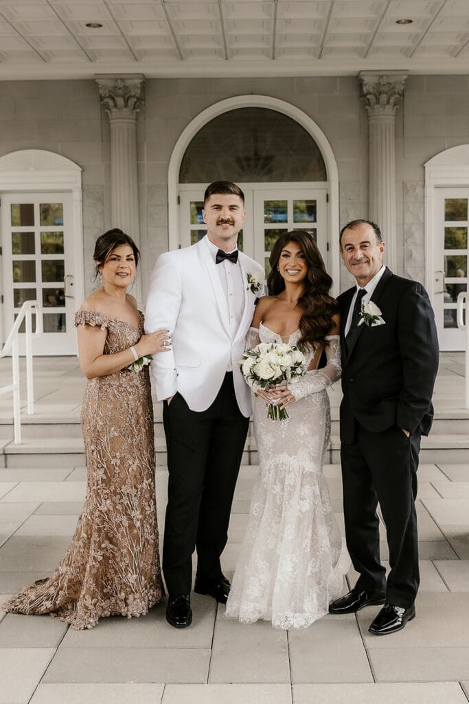 Bride and groom posing with the brides parents.