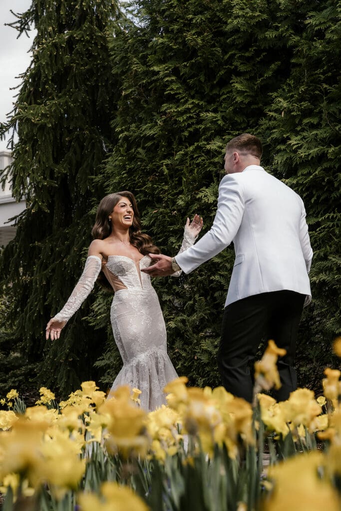 Groom turning around in shock to see the bride during their first look in the garden area at The Palace at Somerset Park.