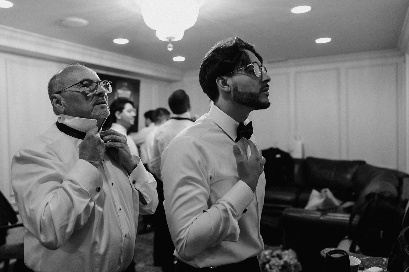 Black and white photo of the groom and a groomsmen getting ready in The Grooms Suite at Nanina's in the Park.