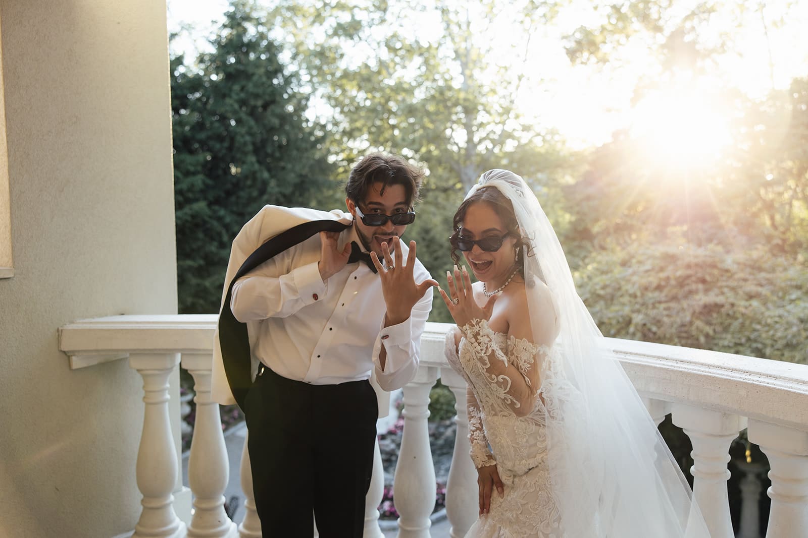 Golden hour photo of a bride and groom showing off their rings on a balcony at Nanina's in the Park in New Jersey.