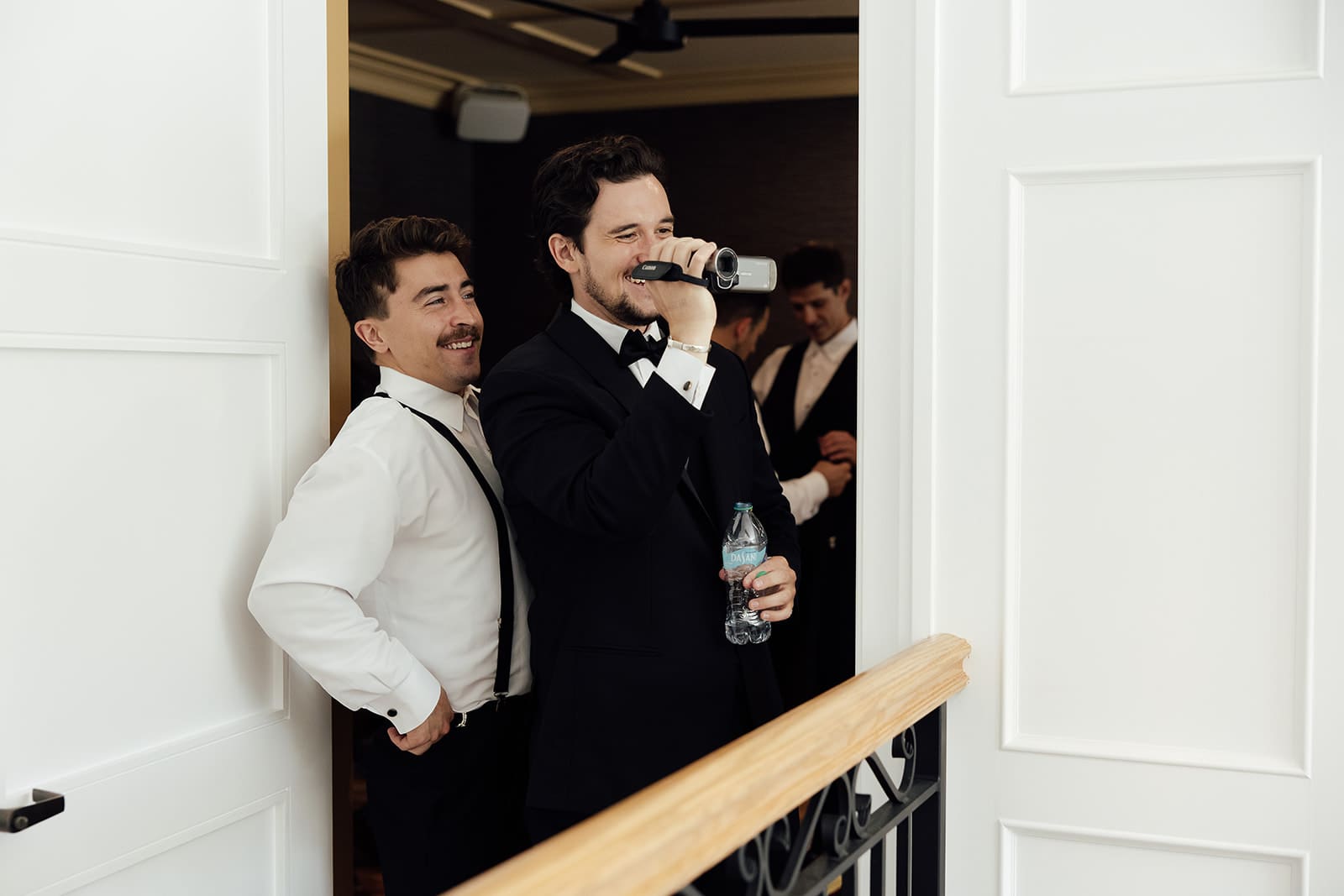 Groomsmen recording the groom as he gets ready.