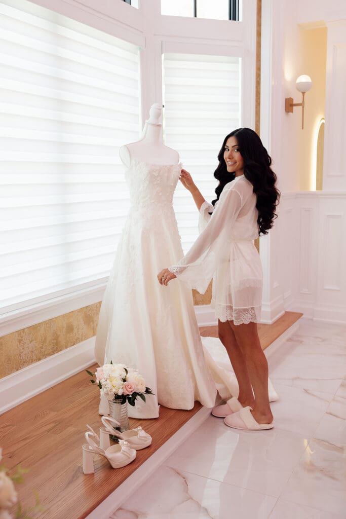 Bride admiring her wedding dress inside the bridal suite at The English Manor in Ocean, New Jersey. 