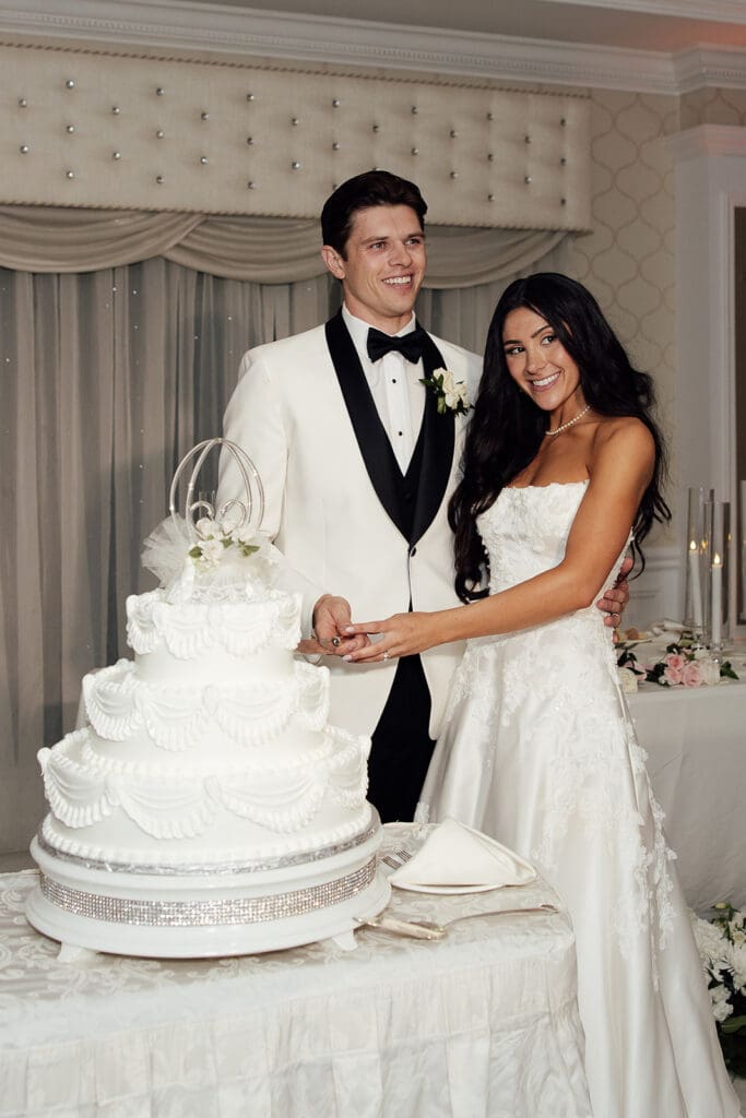 Bride and groom cutting into their wedding cake during their English Manor wedding reception in NJ.