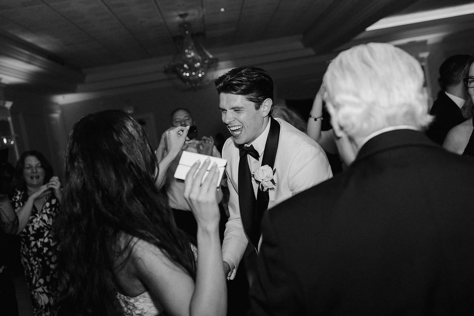 Black and white photo of a bride and groom dancing during their English Manor wedding reception in The Ballroom.