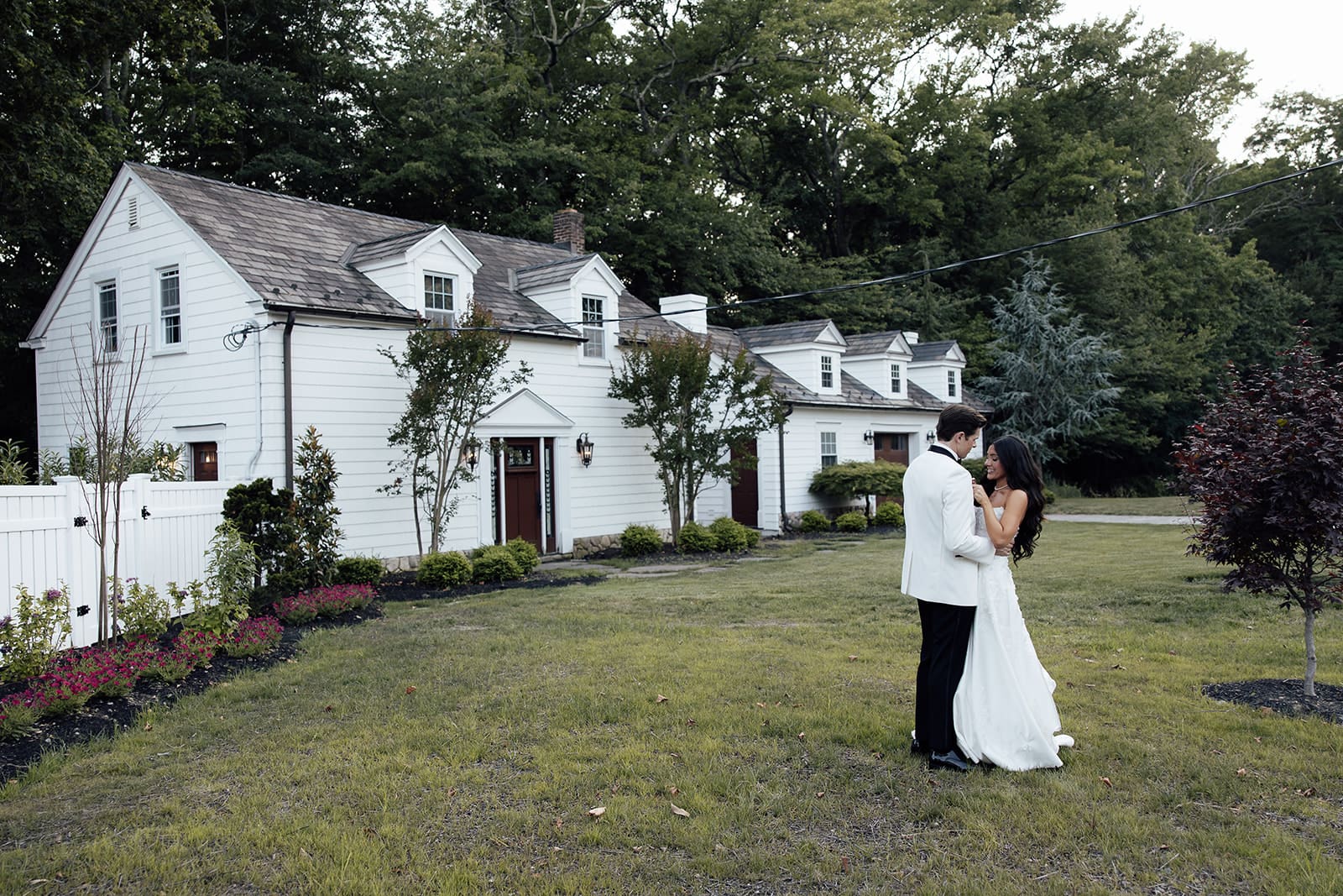 Bride and groom posing for portraits in the front of The English Manor in Ocean, New Jersey. 